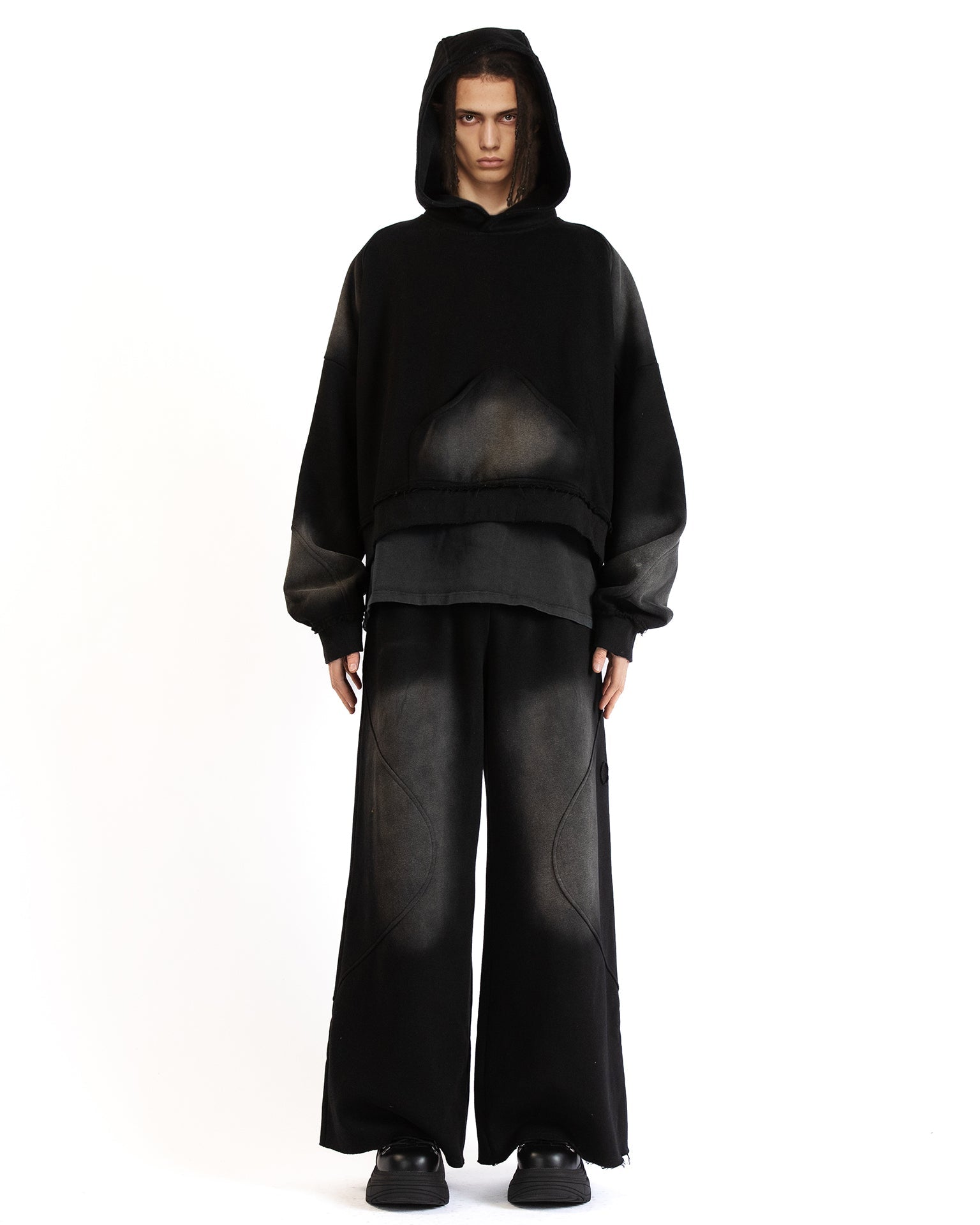 Front view of the Untitled Artworks Consumed Hoodie in black, showcasing its oversized fit, kangaroo pocket, and unique stone wash effect.