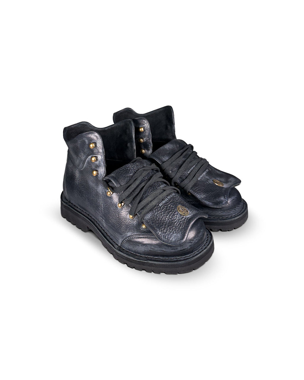 Close-up 3/4 tongue down view of the Untitled Artworks x Fracap Destroyer Boot in black, showcasing its spray-effect finish, oversized fold-over tongue, and antique brass eyelets.
