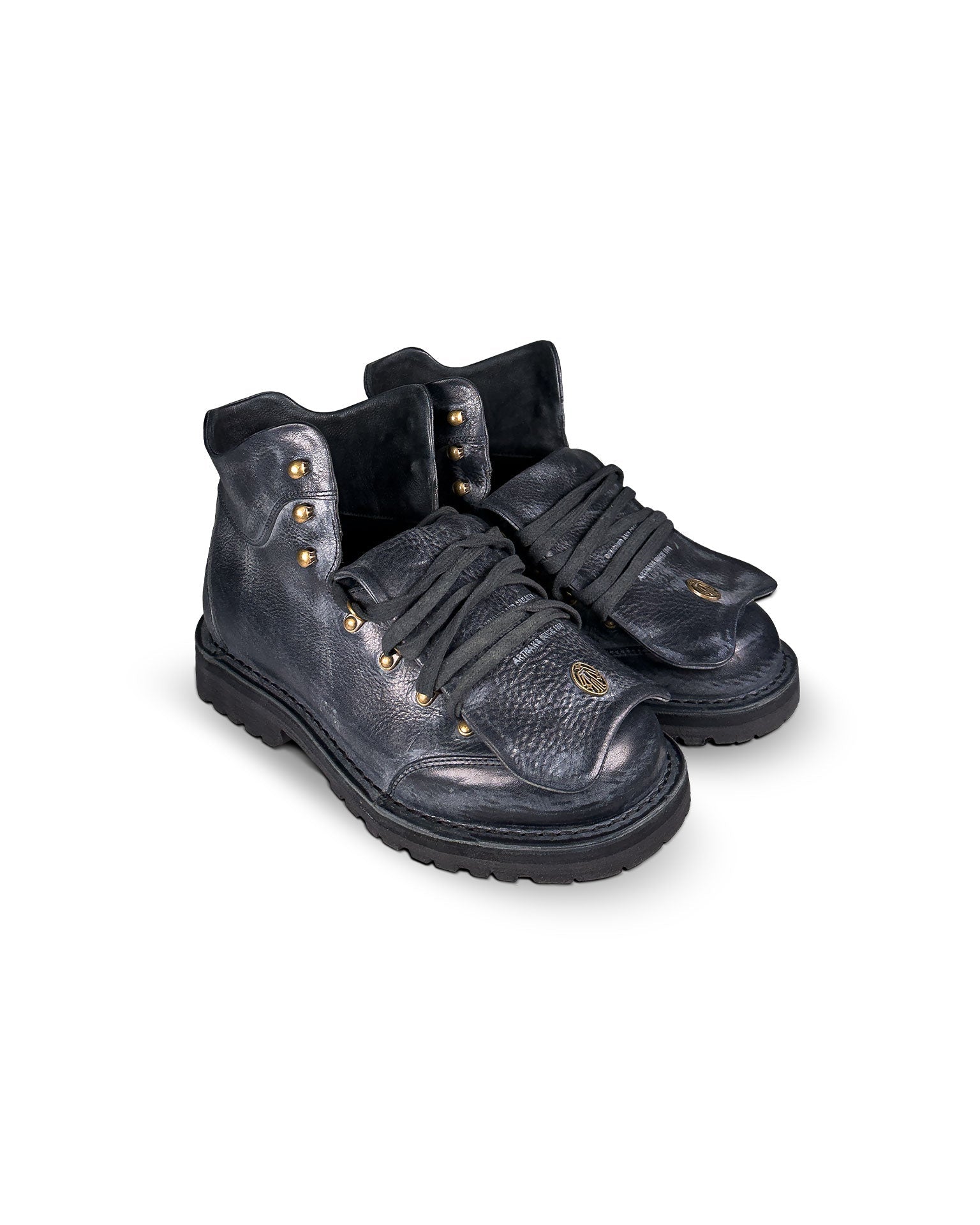 Close-up 3/4 tongue down view of the Untitled Artworks x Fracap Destroyer Boot in black, showcasing its spray-effect finish, oversized fold-over tongue, and antique brass eyelets.